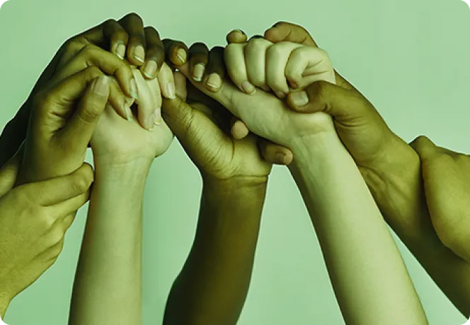 Mãos de diferentes tons de pele entrelaçadas representando união e diversidade